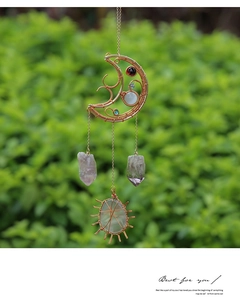 Detail of handmade wire-wrapped crystal moon sun catcher with beads and raw stones
