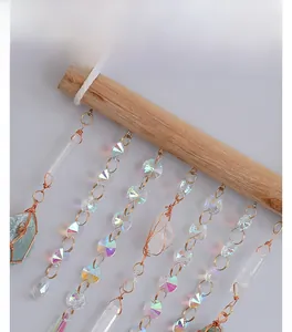 Detail of handcrafted wooden wall hanging with natural crystal prisms and wire-wrapped stones