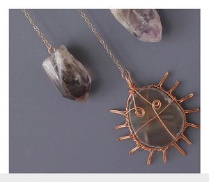 Macro view of wire-wrapped natural amethyst crystal with copper weaving details