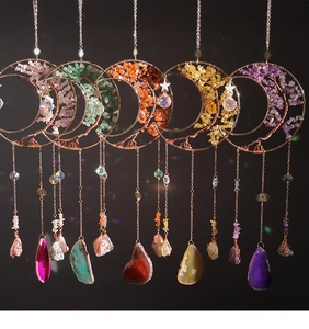 Detail of moon-shaped crystal suncatchers with tree of life and natural healing stones