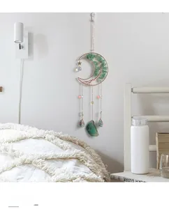 Detail view of moon-shaped crystal dreamcatcher hanging in a cozy bedroom setting