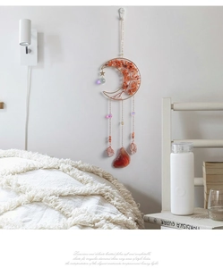 Detail of moon suncatcher with carnelian tree of life and crystals on bedroom wall