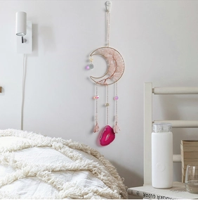 Detail of moon-shaped rose gold wall decor with rose quartz tree and pink agate slice
