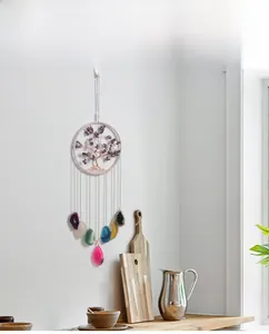 Detail of tree of life suncatcher with colorful agate slices on white wall