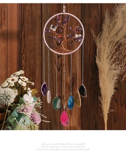 Macro view of crystal tree of life suncatcher with colorful natural agate slices hanging