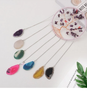 Detail of tree of life suncatcher with healing agate slices and purple crystals