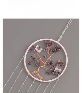 Detail of tree of life wall decor with purple crystals and pink frame on grey background