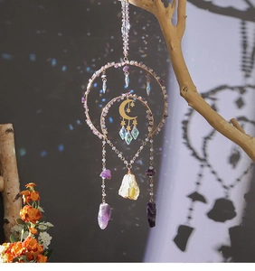Detailed view of suncatcher with amethyst stones and golden celestial charms on branch