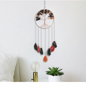 Detailed tree of life wind chime with agate slices hanging on a minimalist white wall