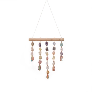 Bohemian wall hanging with natural raw crystals and colorful stones on a wooden rod