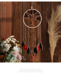 Detail of tree of life wind chime with healing crystals and agate slices on wooden background