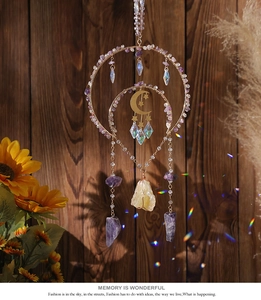 Detail of amethyst suncatcher with golden moon stars and crystal prisms on wood