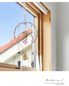 Detail of natural amethyst suncatcher showing rainbow light refraction by a window