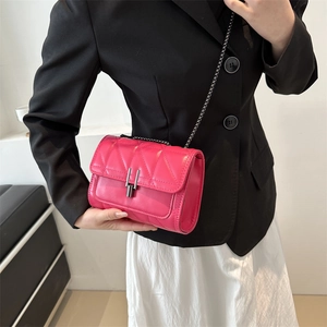 Petit sac à bandoulière matelassé fuchsia avec chaîne en métal sur tenue élégante