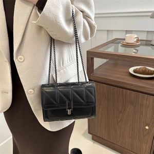Quilted black leather shoulder bag with metal chain strap and sleek minimalist design