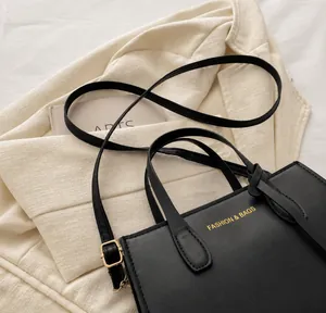 Close-up of black leather square tote with gold Fashion & Bags lettering and strap