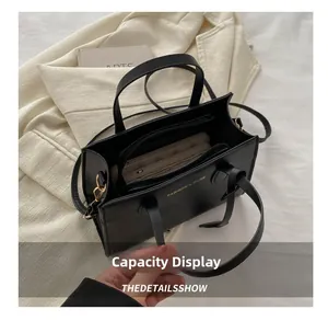 Top view of black PU leather bag interior with multiple compartments and gold lettering