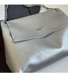 Detail der silbernen Metallic-Ledertasche mit Magnetklappe und Kettenriemen