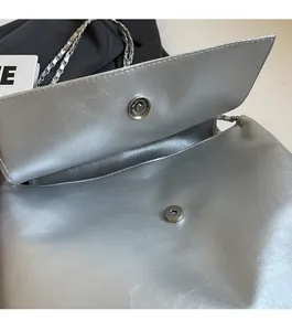 Detail der silbernen Metallic-Tasche mit Magnetverschluss und eleganter Ketten-Schulterriemen