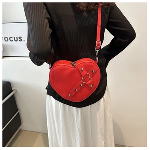 Modèle montrant la taille et l'ajustement du sac à bandoulière rouge en forme de coeur