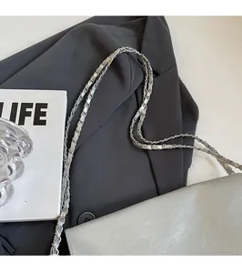 Detail der silbernen Metallic-Tasche mit Kettenriemen und weicher Lederstruktur