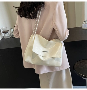 Klassische cremeweiße Ketten-Einkaufstasche, elegant kombiniert mit einem rosa Blazer