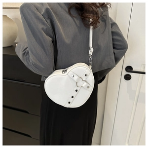 Modelweergave van witte hartvormige PU-lederen tas met studs en metalen gesp