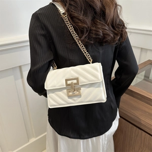 Elegant white quilted crossbody bag with gold chain strap shown on a female model