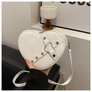 Détail du sac blanc en forme de cœur avec rivets argentés et boucle métallique