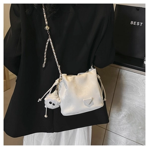 Witte emmertas met gouden ketting en pluche bedeltje gedragen door een model