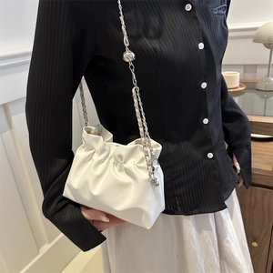 Chic white pleated cloud bucket bag with silver metal chain strap shown on a model