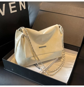 Nahaufnahme der beigen Lederhandtasche mit Silberkette in einer edlen Geschenkbox