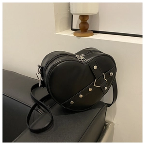 Detail van zwarte hartvormige leren tas met zilveren studs en hartvormige metalen gesp