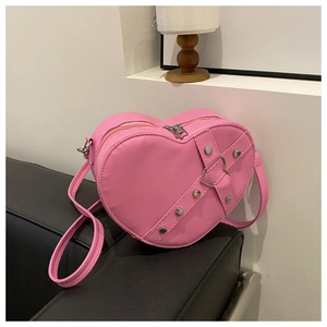Detailopname van de roze hartvormige tas met zilveren klinknagels en metalen details