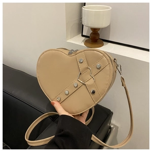 Détail du sac en forme de cœur kaki avec rivets argentés et fermoir métallique