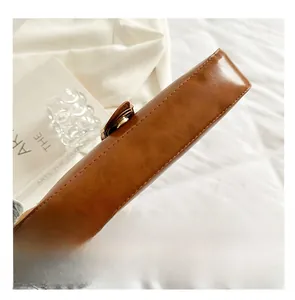 Detailed view of precision stitching and smooth leather finish on a brown baguette bag