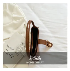 Detailed view of caramel leather shoulder bag interior with zipper pocket and metal buckle