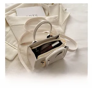 Internal capacity view of a beige leather mini shoulder bag showing makeup accessories