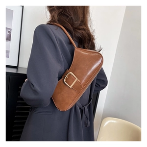 Brown retro baguette bag detail featuring large gold buckle on smooth PU leather strap