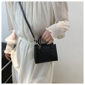 Minimalist black PU leather mini square bag with golden hardware and slim shoulder strap