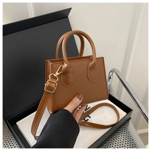 Close-up of brown PU leather mini tote bag with adjustable strap and dual handles