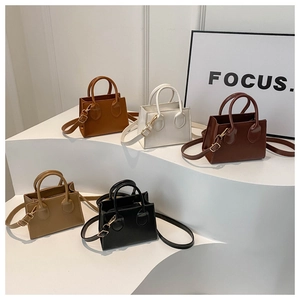 Detailed collection of five mini tote bags in various colors on white display stands