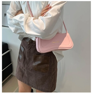 Close-up of pink leather underarm bag with Miss cute gold lettering on model