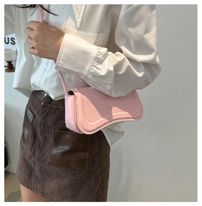Close-up of pink faux leather underarm bag with Miss Mini logo and curved design