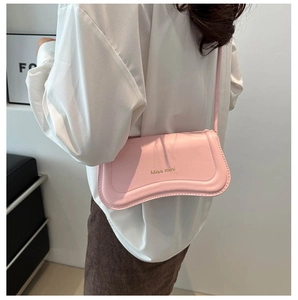 Detail view of the pink leather shoulder bag with gold Miss mini logo and slim strap