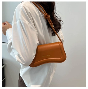 Detail of the Miss Mini caramel leather shoulder bag with a knotted strap and gold logo