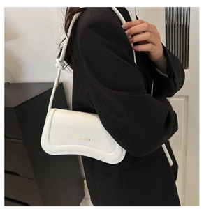 Close-up of white leather underarm bag with knotted strap and gold miss mini logo