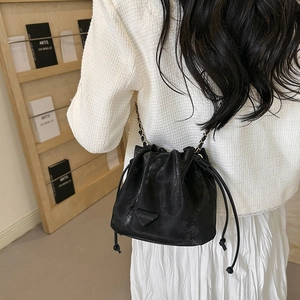 Sac seau noir chic avec cordon, cuir texturé et bandoulière chaîne élégante pour femme