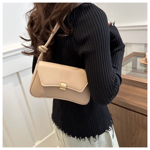 Detail of a beige leather shoulder bag featuring a knotted strap and golden square buckle