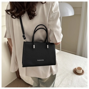 Détail du sac bandoulière noir en cuir grainé avec finitions argentées et logo fashion